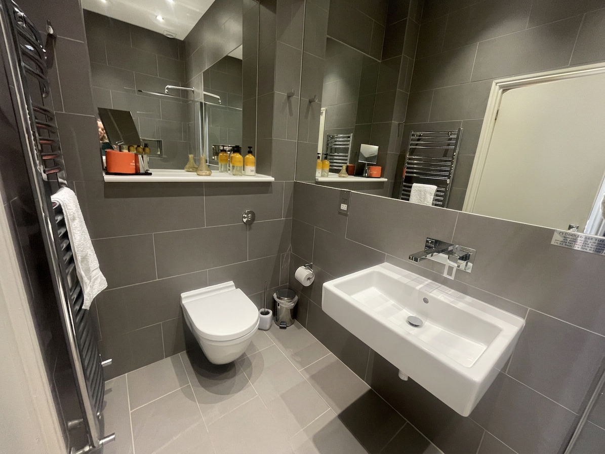 Hastings House ensuite bathroom with heated towel rail and wall-hung sink