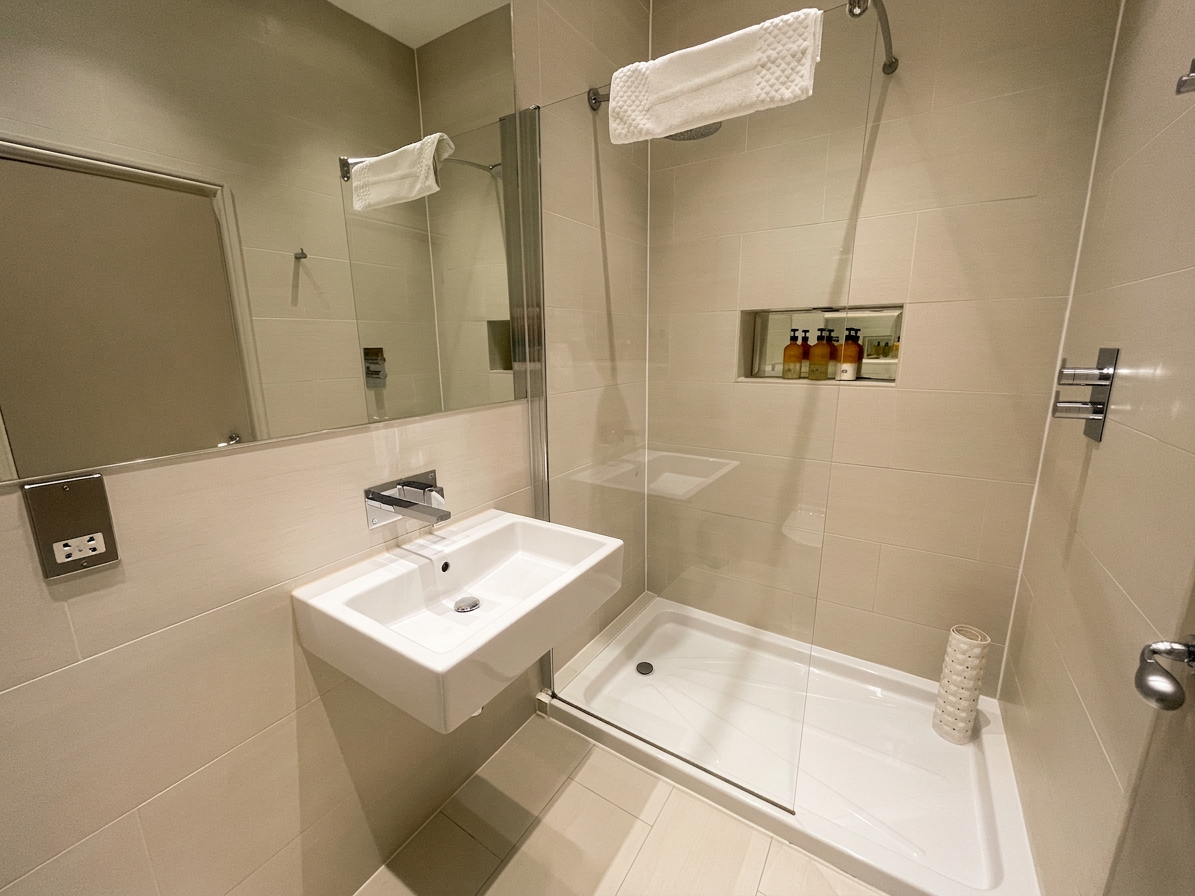Hastings House ensuite shower room in warm neutral tiling