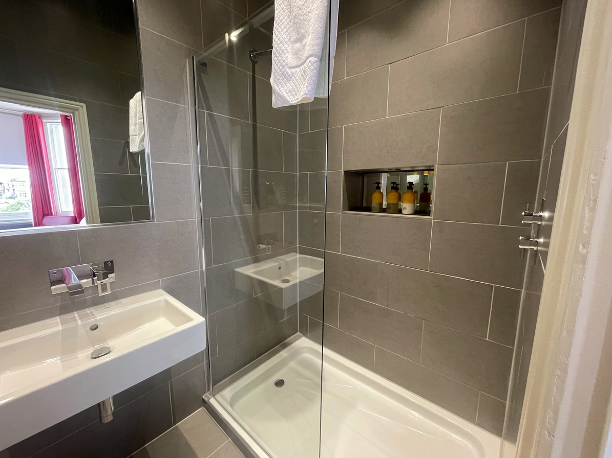 Hastings House ensuite shower room with sea-view window