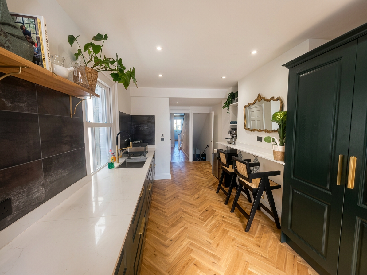 Hastings House galley kitchen with dark green cabinetry and herringbone floor