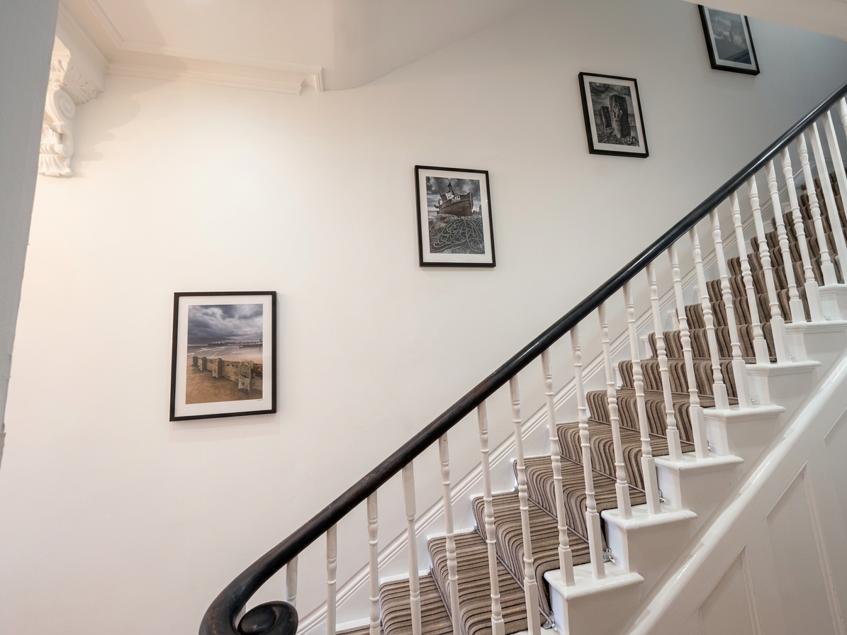 Hastings House staircase with framed coastal photography