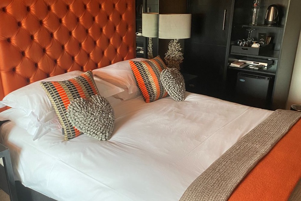 Hastings House orange bedroom with tufted headboard